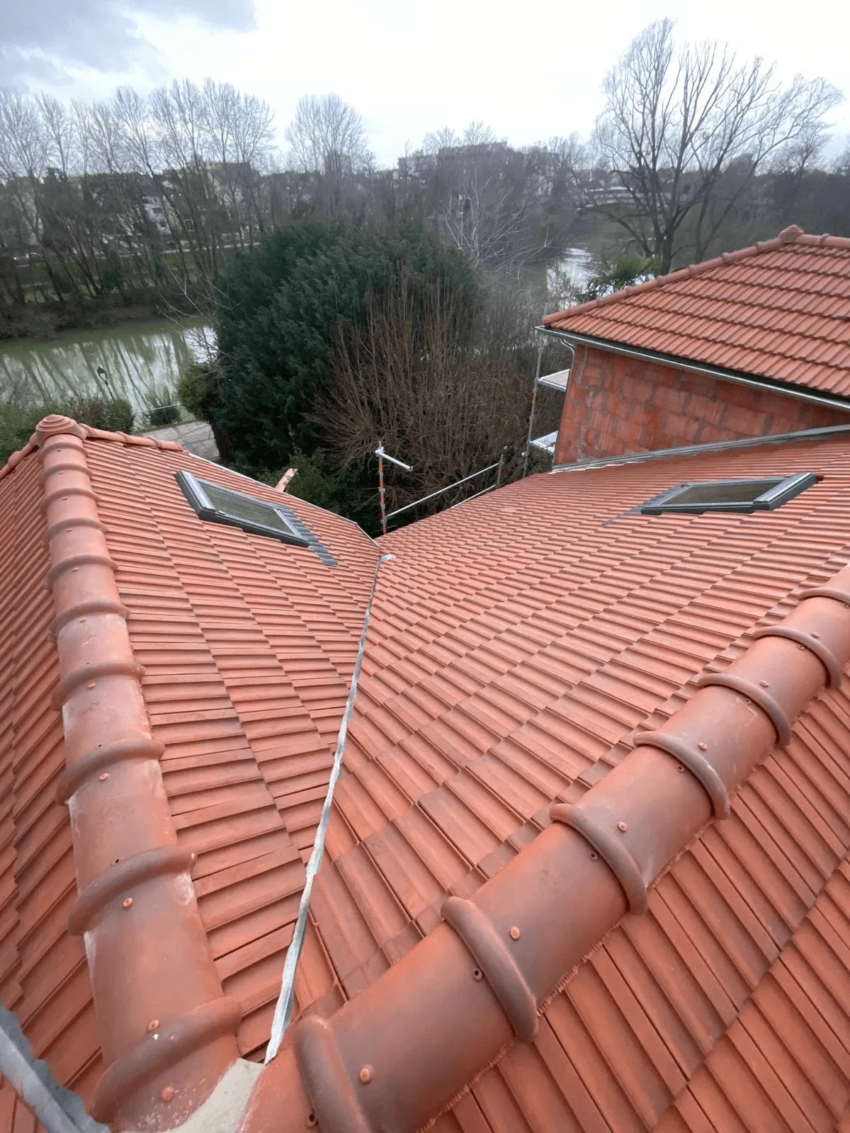 Pans de toiture en tuiles rouges et lignes de faîtage